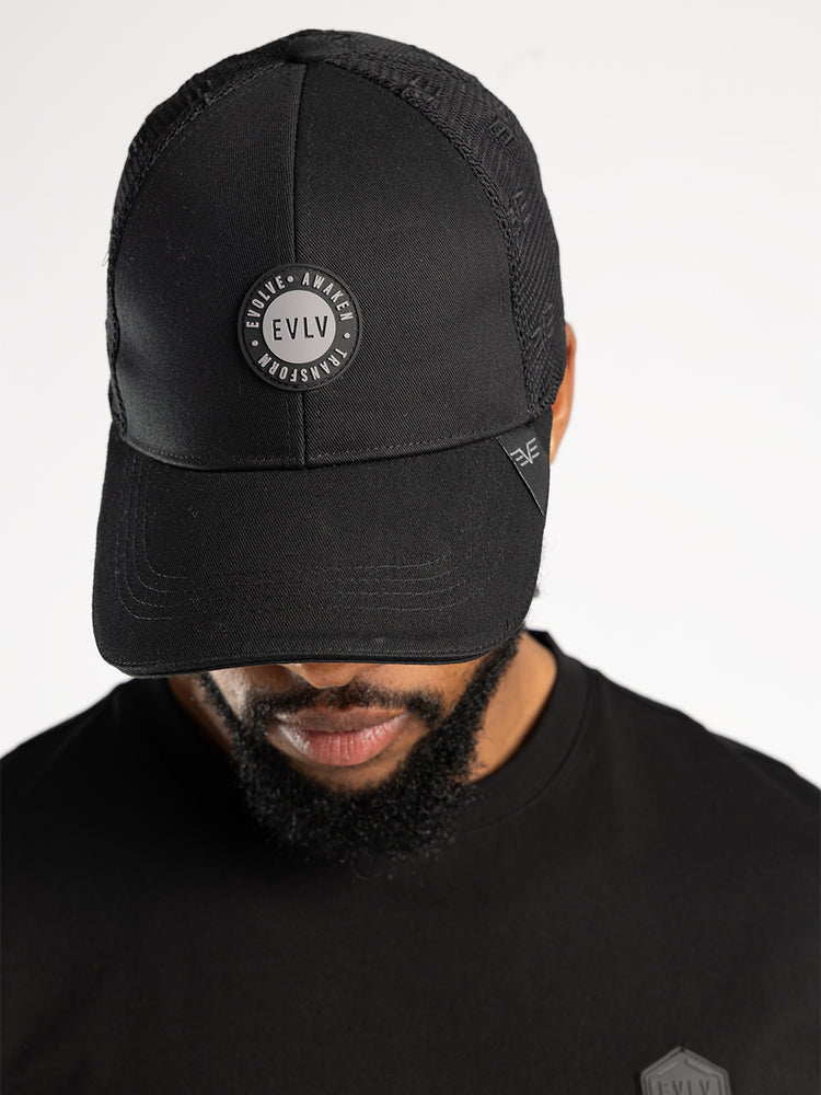 Evolve Black Polyester Trucker Cap.AOP And Rubber Badge.